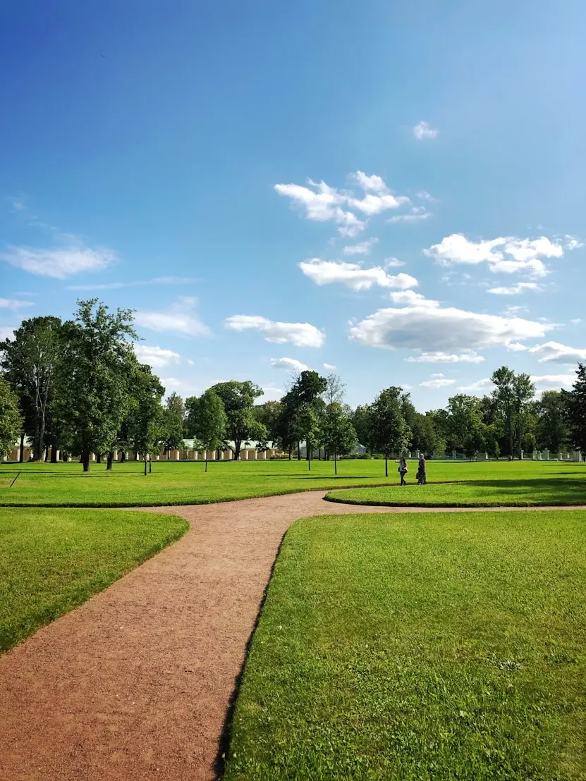 Park s posečeným trávníkem a mlatovou cestou